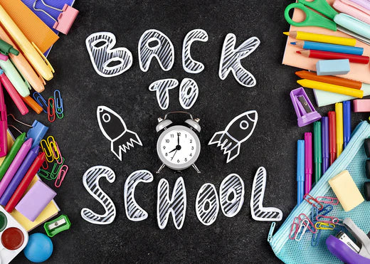 A collection of school supplies and a clock arranged on a black background, symbolizing the back-to-school season.