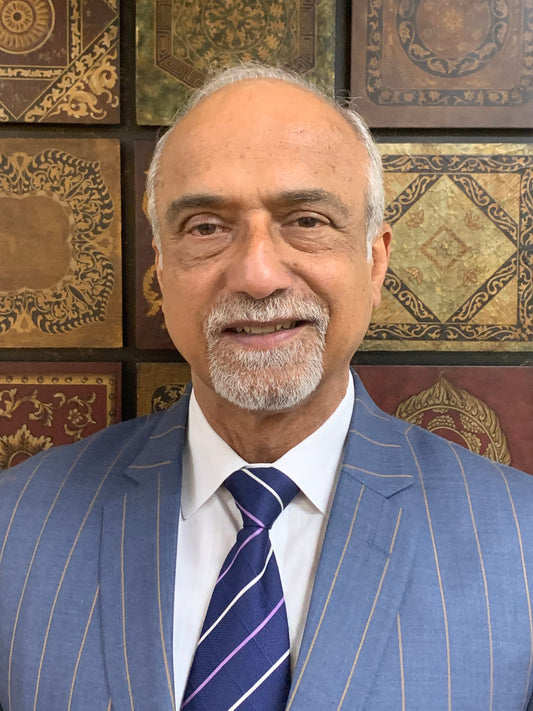 An Indian man dressed in a formal suit and tie, exuding professionalism and elegance.