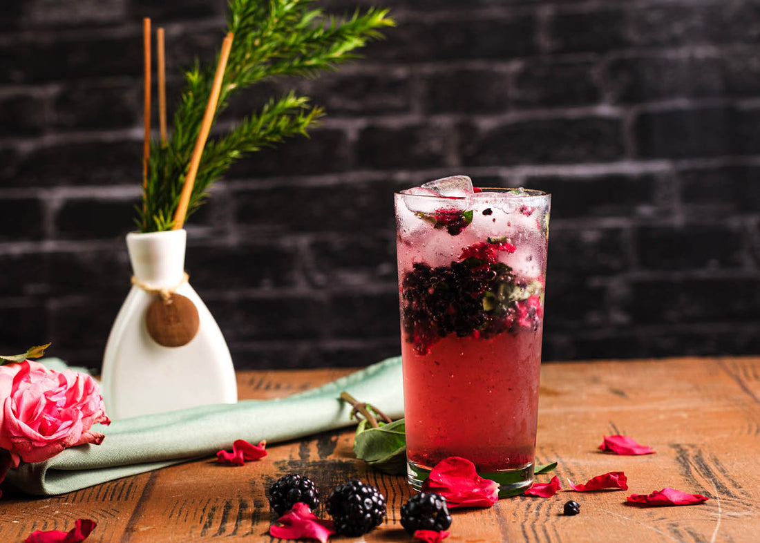 A vase with a flower and a two baslis, a berry, a rose drink elegantly placed on a table, creating a serene and inviting atmosphere.