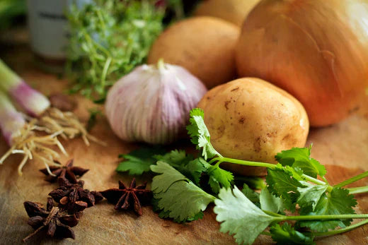 A wooden cutting board adorned with an assortment of fresh vegetables and vibrant herbs, ready for meal preparation.