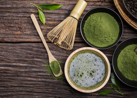 A close-up view of vibrant matcha green tea powder in a small bowl, showcasing its rich color and fine texture.