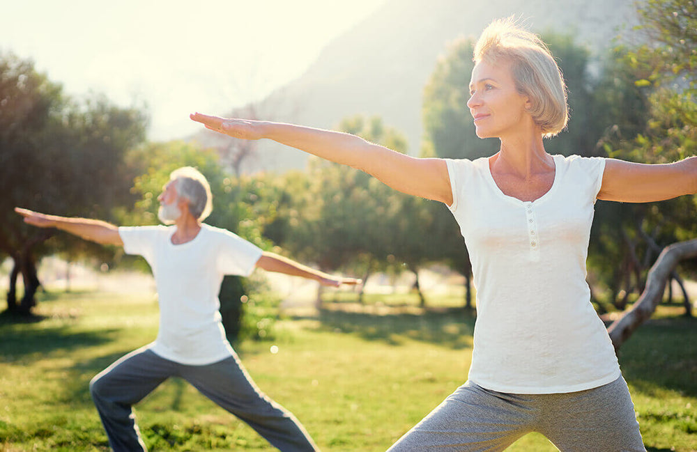 
              a menopause-age woman in the park practicing tai-chi in the sun
